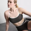Aktives Crop-Top mit kontrastfarbener Paspelierung und gekreuztem Rücken Aktives Crop-Top mit kontrastfarbener Paspelierung und gekreuztem Rücken