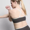 Aktives Crop-Top mit kontrastfarbener Paspelierung und gekreuztem Rücken Aktives Crop-Top mit kontrastfarbener Paspelierung und gekreuztem Rücken